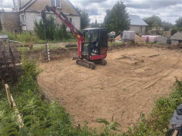 Minikoparka na przygotowanym placu pod fundamenty domu jednorodzinnego na Podlasiu